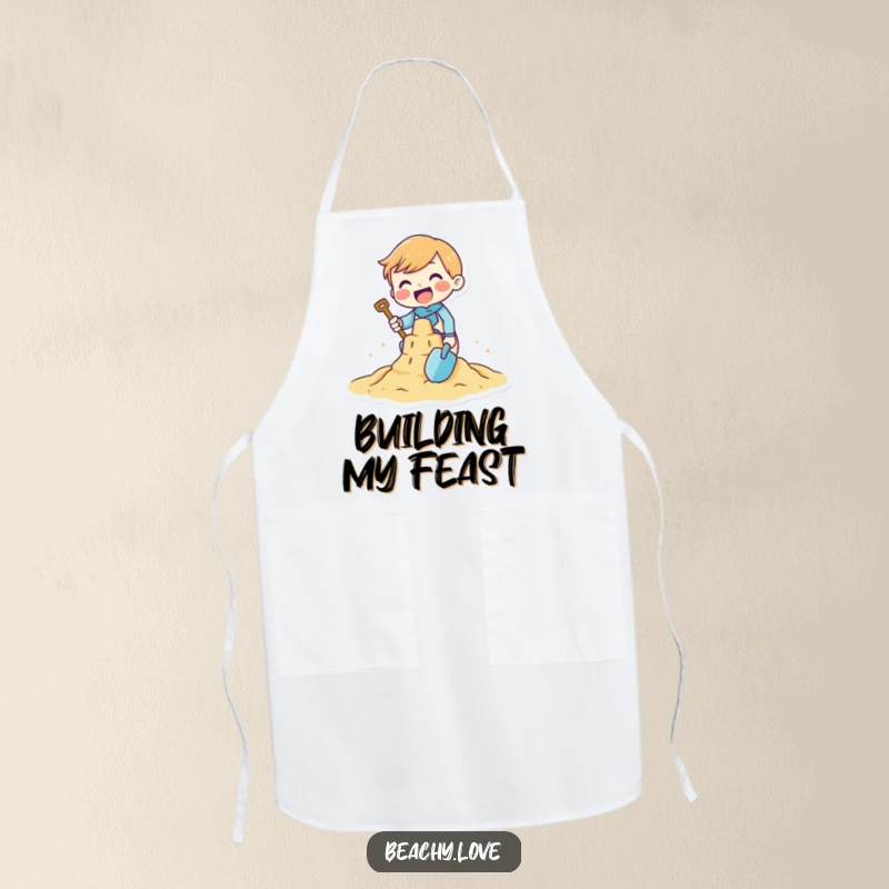 Funny apron featuring a tiny character gleefully building a sandcastle with a tiny shovel, perfect for kitchen fun or beach days.