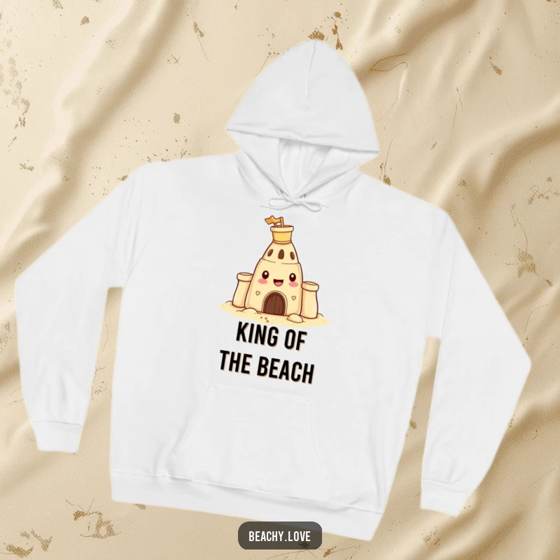 Funny hoodie featuring a happy sandcastle with a tiny bucket and spade on its head, offering warmth and beachy cheer.