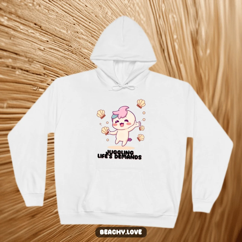 Funny hoodie with a delighted kawaii character juggling seashells, radiating warmth and playful charm.